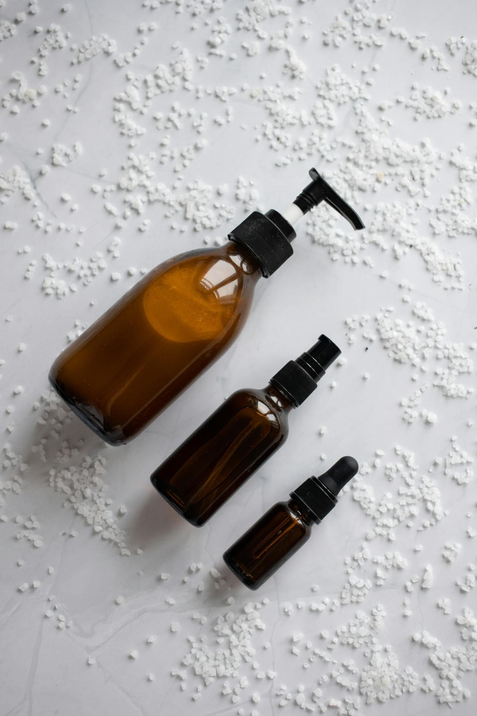 Flat lay of amber dropper and pump skincare bottles representing a dark spot fading routine