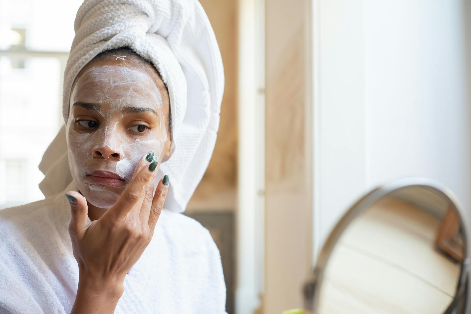 Woman applying tretinoin cream to face during evening skincare routine