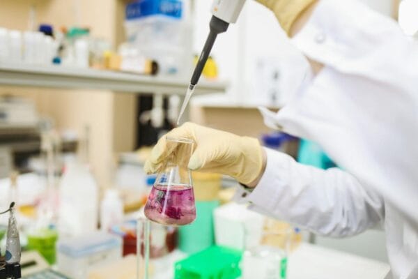 Scientist pipetting sample in research laboratory illustrating NAD+ coenzyme study