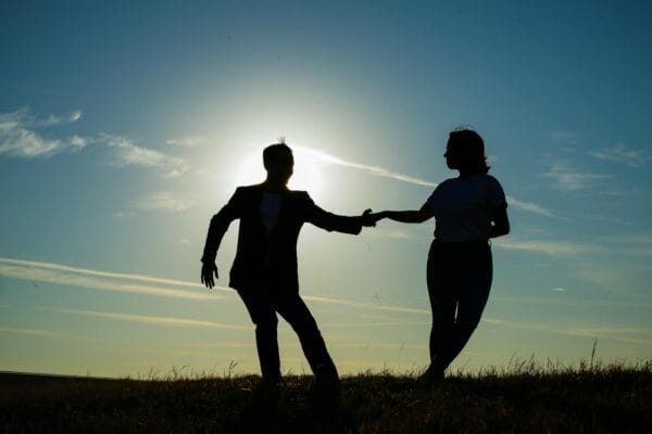 Couple silhouette holding hands at sunset representing PT-141 bremelanotide sexual health research