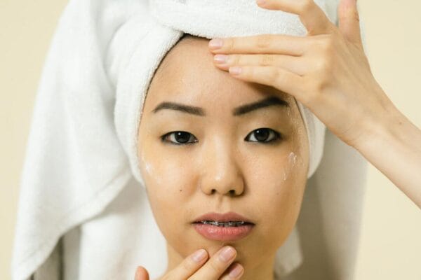 Woman applying cosmetic product to face — hair and skin research
