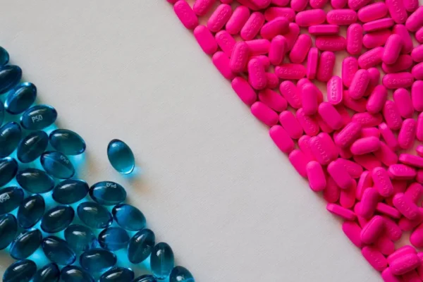 Pink and blue pain relief tablets and capsules close up