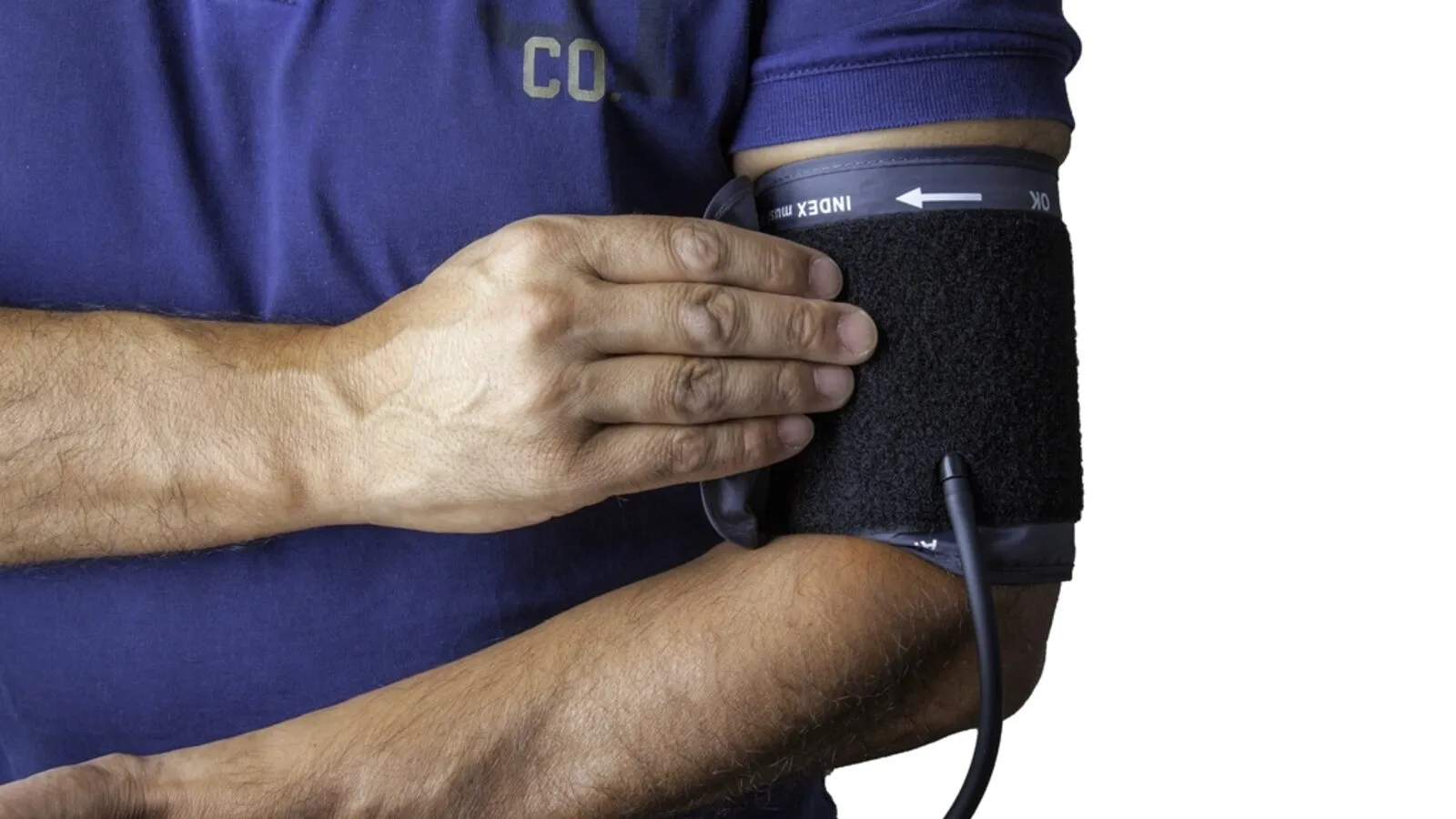 Senior man measuring his blood pressure with a home arm-cuff monitor