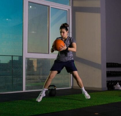 Woman working out with medicine ball indoors — anti-inflammatory research