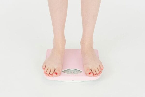 Woman measuring weight on bathroom scale — CagriSema research