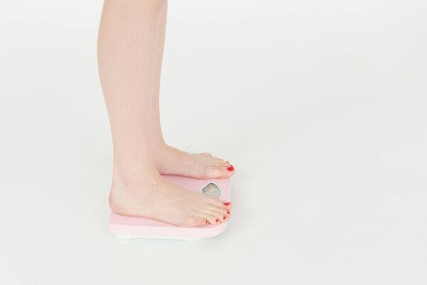 Woman on weight scale side view — amylin research