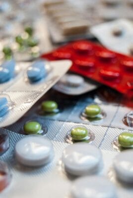 Multiple sildenafil blister packs in different colours and strengths arranged on a flat surface, illustrating the Cenforce 100 vs 150 vs 200 mg dose-selection question