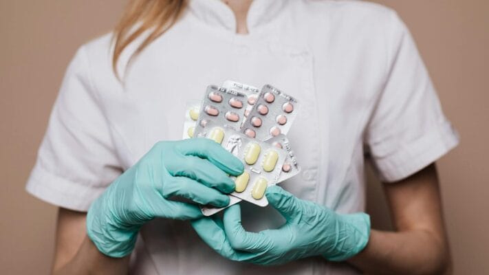 Healthcare professional with medication blister packs — Clomid vs letrozole fertility comparison