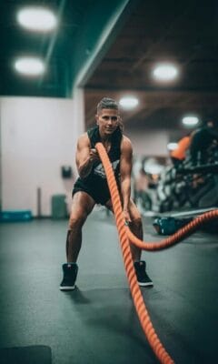 Athlete performing intense battle rope exercise — muscle research