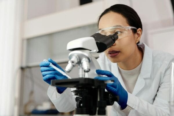 Female scientist examining samples under microscope — GHRP research