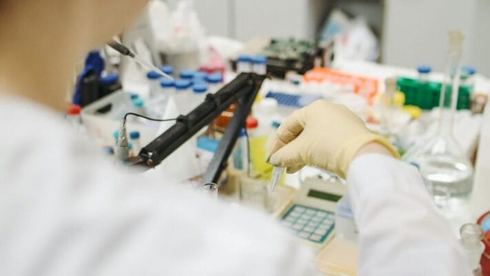 Laboratory researcher with test tubes representing PCT bloodwork monitoring