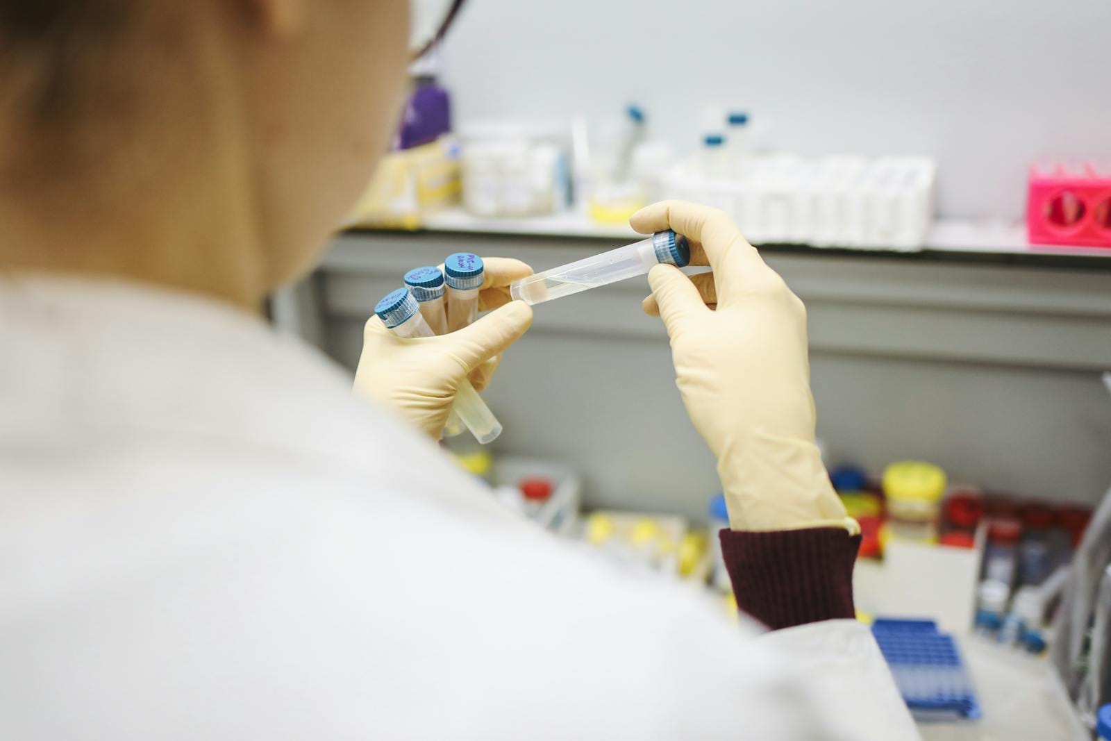Researcher inspecting Hexarelin peptide reconstitution vials in laboratory