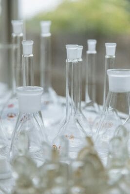 Empty glass laboratory flasks and beakers in soft light — reconstitution research