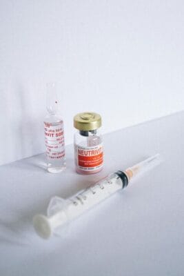 Medical vial and syringe on white background — injection research