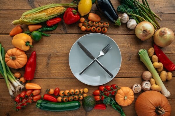 Empty plate with fresh vegetables — intermittent fasting eating window with HCG