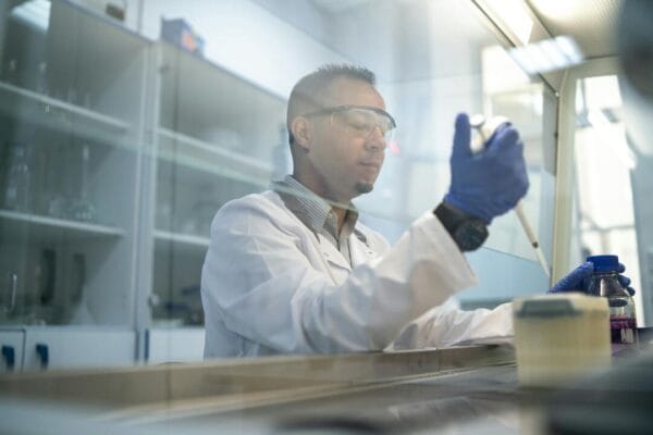 Scientist with pipette in laboratory — peptide research