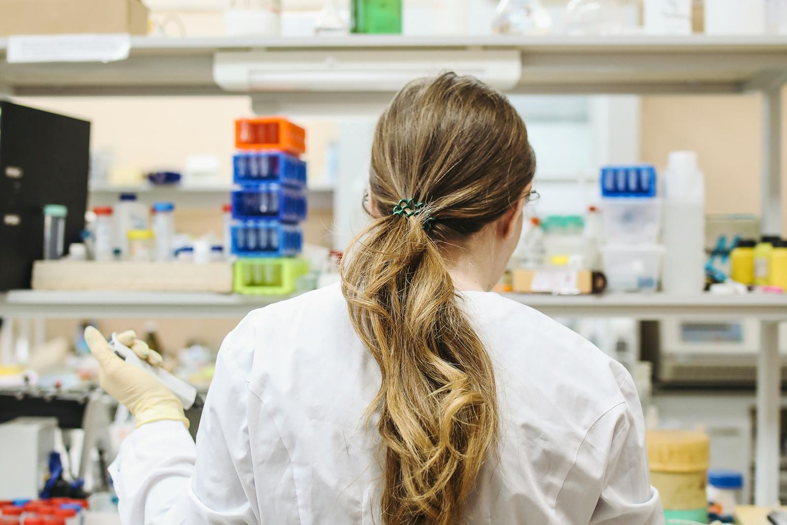 Laboratory researcher with reagent racks during cathelicidin LL-37 peptide research