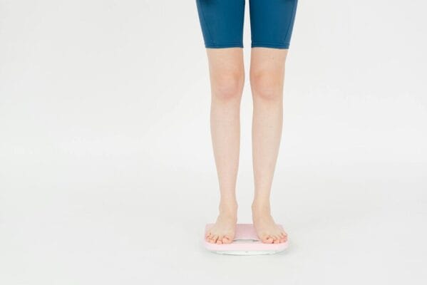 Person in sportswear on weight scale — incretin research