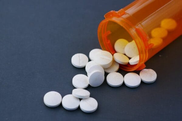 White pills spilling from an orange prescription bottle — Pioglitazone vs Metformin