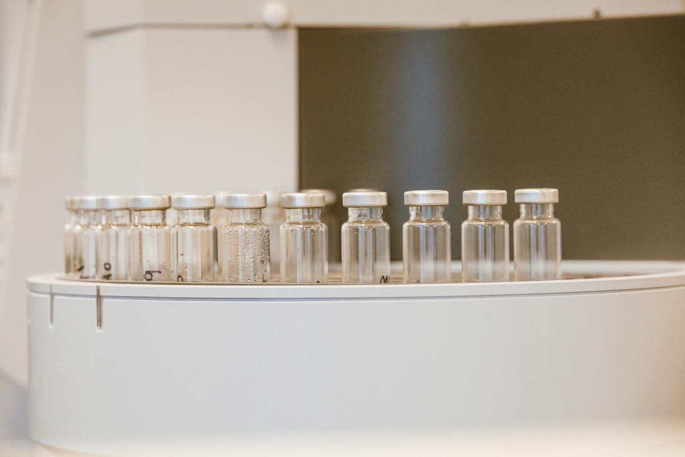 Row of lyophilized peptide vials in a lab carousel — tirzepatide microdosing 0.5mg protocol research preparation