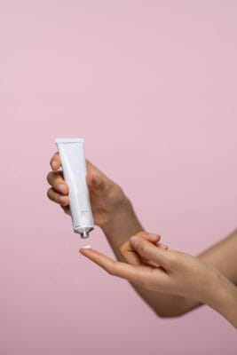 Person applying tretinoin cream from a tube — A-Ret vs Retino-A vs Tretin generic comparison