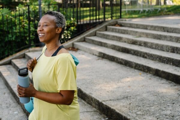 Woman walking outdoors to lower blood pressure through aerobic exercise