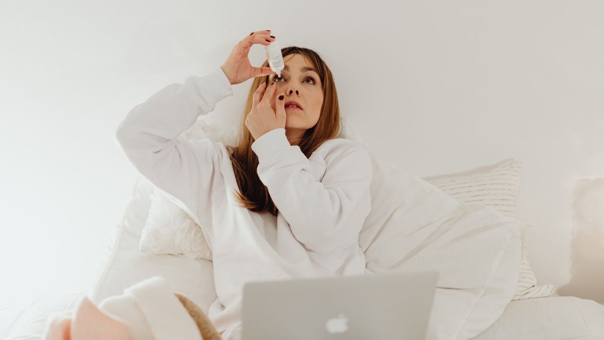 Woman applying antihistamine eye drops for allergic conjunctivitis relief at home
