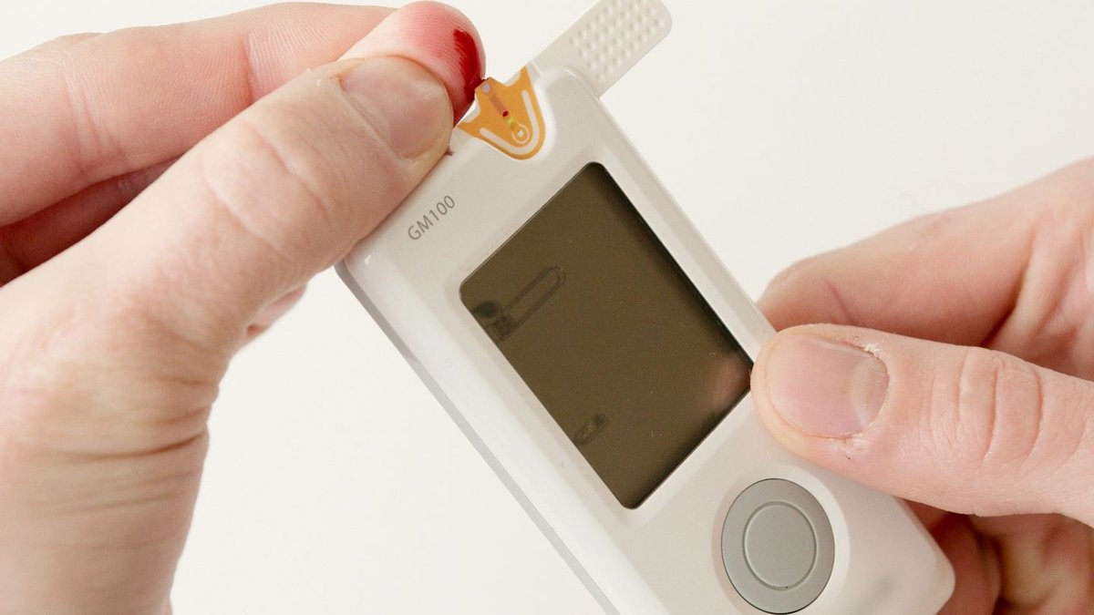 Person using glucometer to test blood glucose levels, relating to metformin diabetes medication